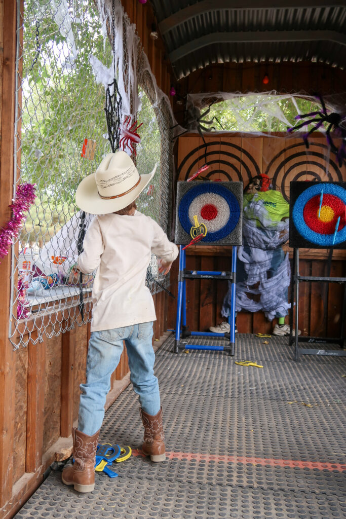 child throwing plastic axes at target 